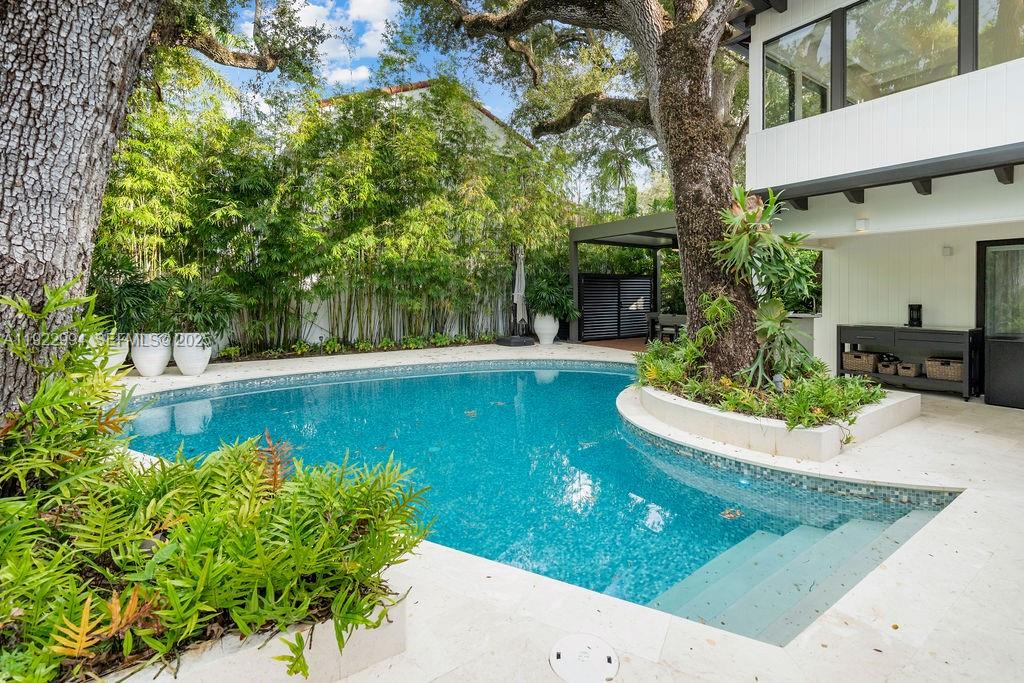4095 Battersea Road Miami, FL 33133 - Photo 73 of 82 a view of a swimming pool with a patio