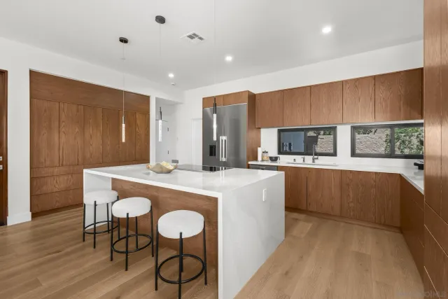 a kitchen with stainless steel appliances granite countertop a kitchen island a stove a sink a dining table and chairs