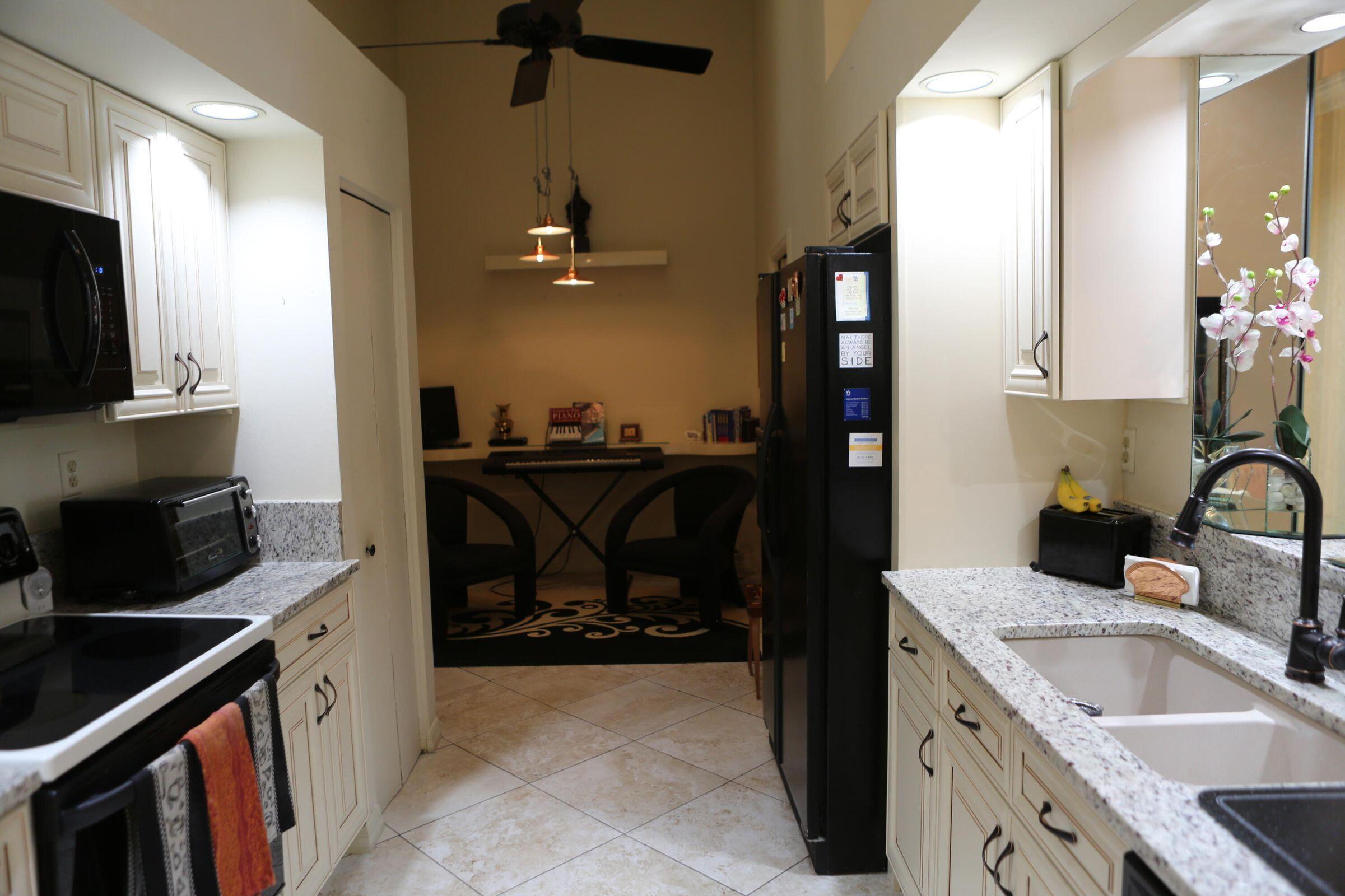 11105 Rios Road Boca Raton, FL 33498 - Photo 2 of 31 a kitchen with a sink stove and cabinets
