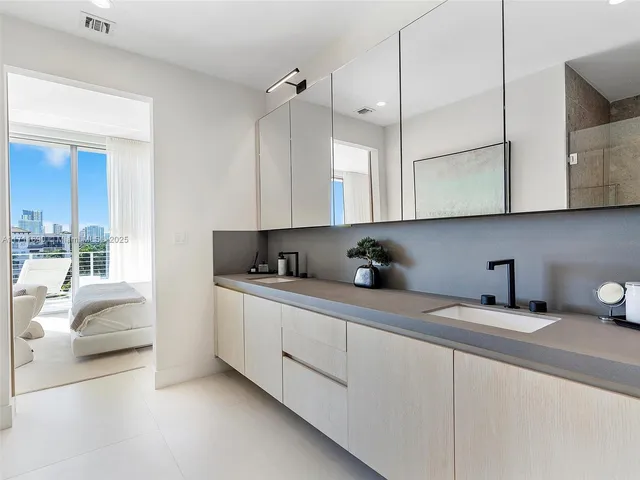 a kitchen with stainless steel appliances granite countertop a sink a stove and white cabinets with wooden floor