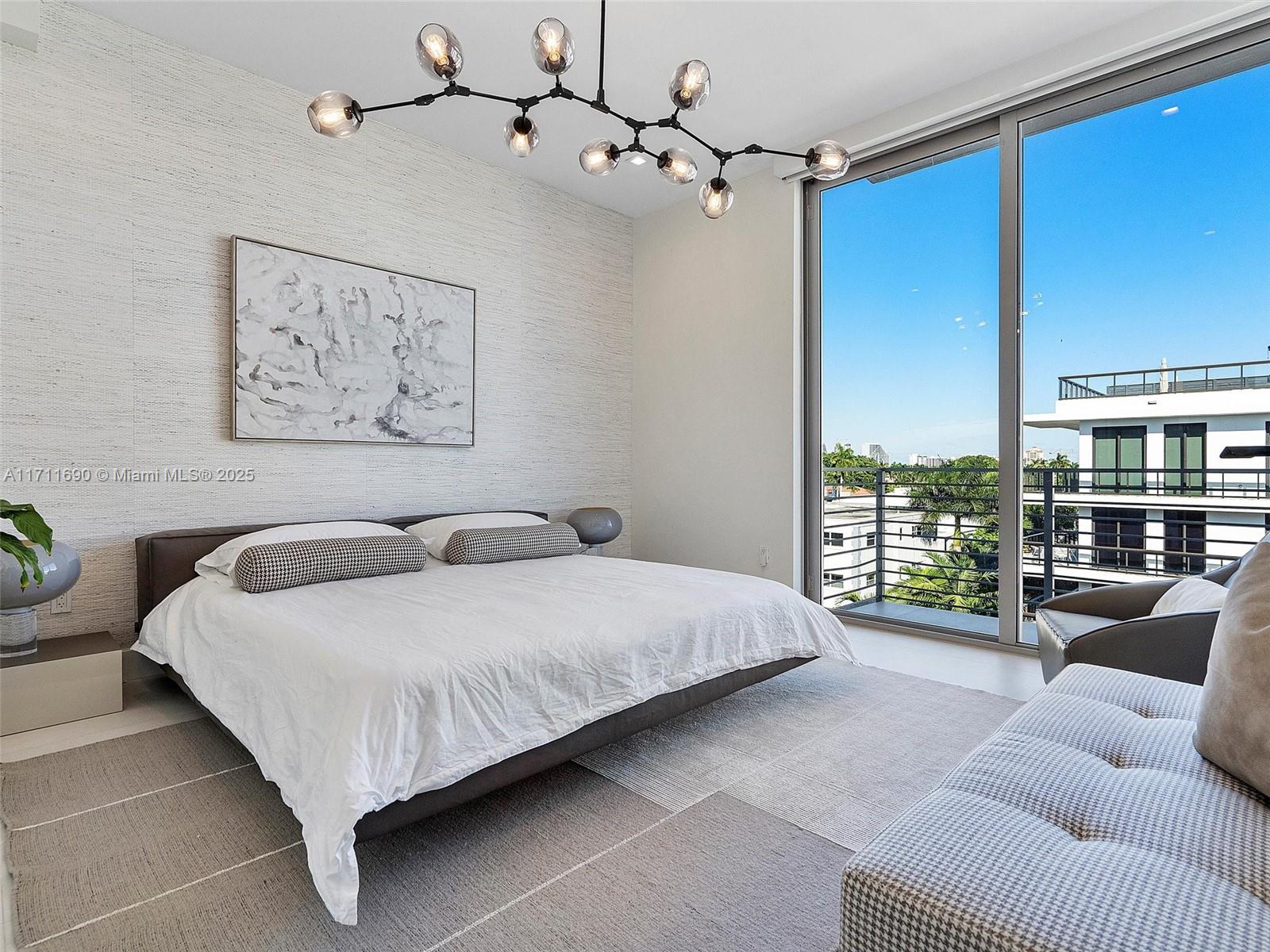 21 Isle Of Venice Drive, Unit PH1 Fort Lauderdale, FL 33301 - Photo 15 of 21 a spacious bedroom with a bed a couch and a window