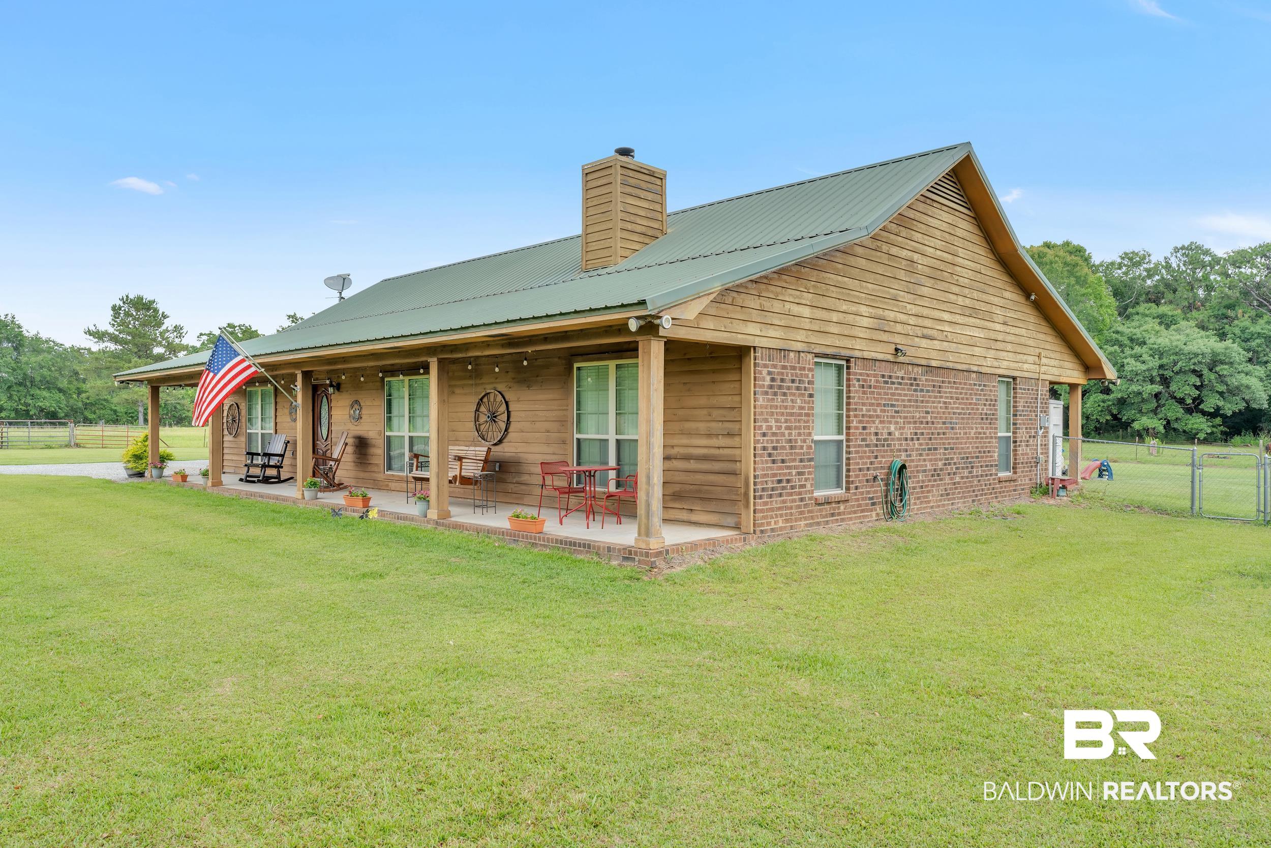 4062 River Road Theodore, AL 36582 - Photo 5 of 32 Rear view of property featuring a chimney, metal roof, and a patio