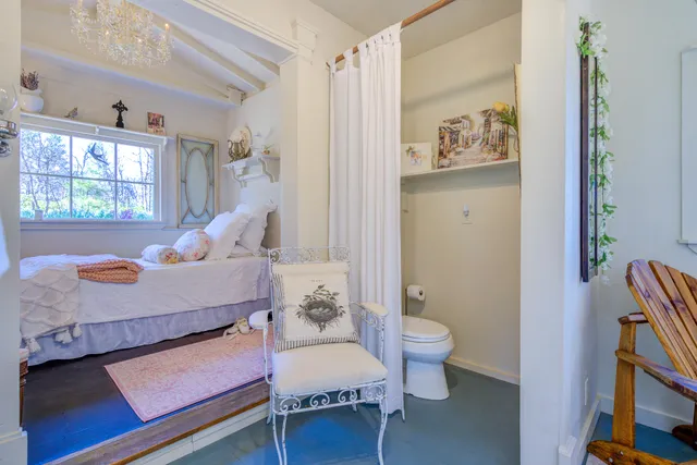 a view of barn with a large window and potted plants