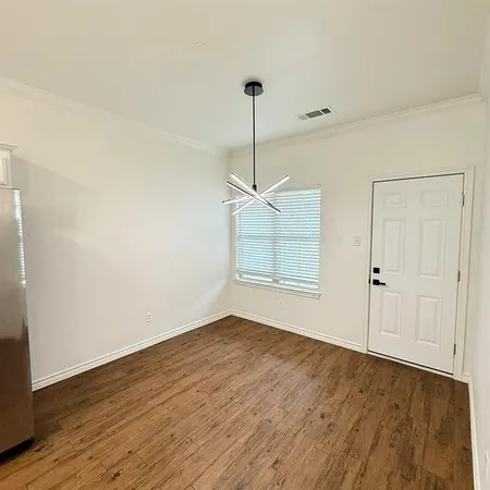 an empty room with wooden floor and ceiling fan