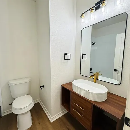 a bathroom with a sink a toilet and mirror