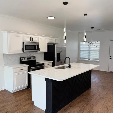 a kitchen with a sink a microwave a stove and refrigerator
