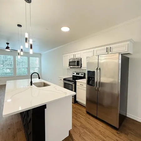 a kitchen with refrigerator cabinets and wooden floor