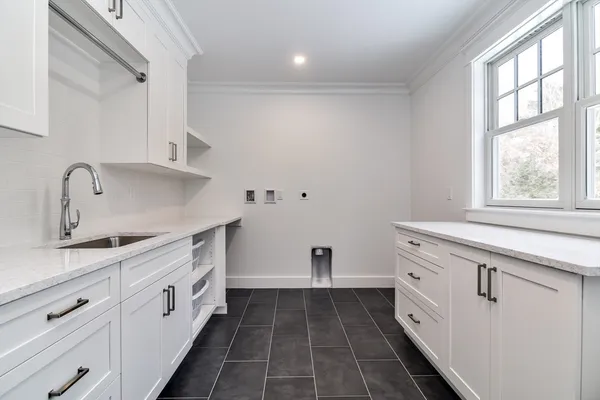 a kitchen with granite countertop white cabinets and window