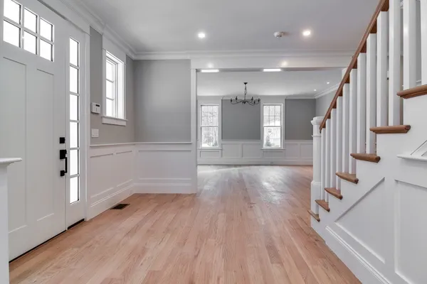 a view of a hallway with wooden floor and staircase