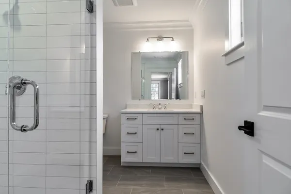 a bathroom with a shower sink and mirror