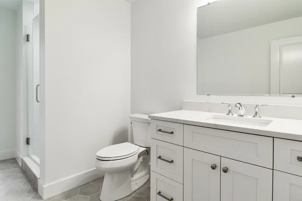 a bathroom with a toilet a sink a vanity and mirror
