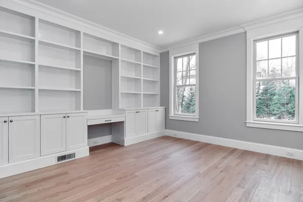 a view of an empty room with a window and wooden floor