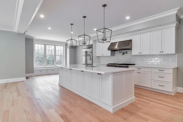 a open kitchen with kitchen island white cabinets and stainless steel appliances