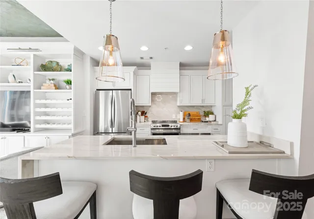 a kitchen with stainless steel appliances granite countertop a sink a stove and a refrigerator