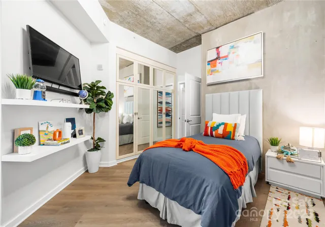 a bedroom with a bed and flat screen tv