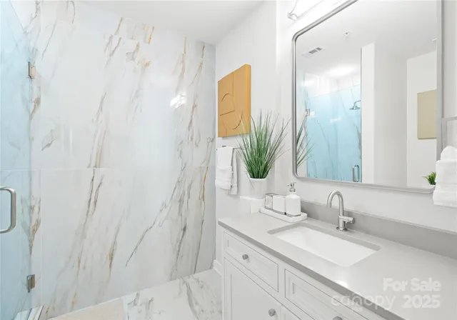 a bathroom with a granite countertop sink and a mirror