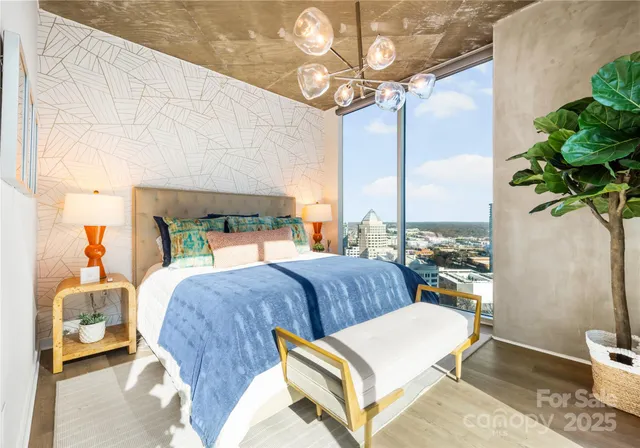 a bedroom with a bed a chandelier and balcony