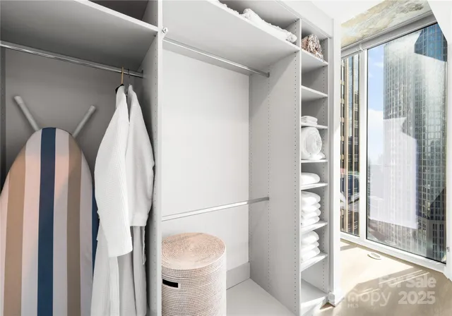 a view of walk in closet with glass door and shower