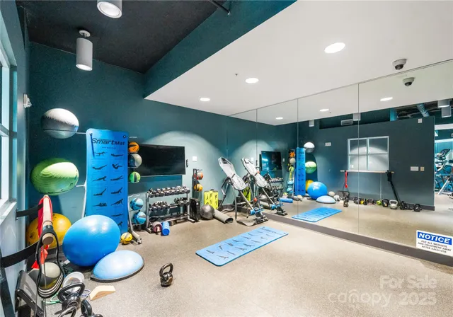 a living room with furniture a flat screen tv and floor to ceiling window