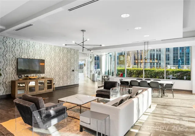 a living room with furniture a flat screen tv and a chandelier