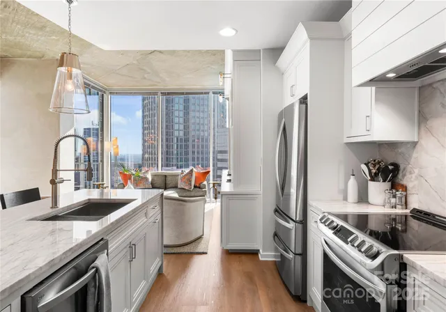 a kitchen with stainless steel appliances granite countertop a sink stove and refrigerator