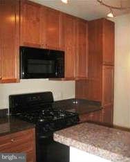 851 North Glebe Road, Unit 1018 Arlington, VA 22203 - Photo 2 of 24 a kitchen with granite countertop stainless steel appliances and wooden cabinets