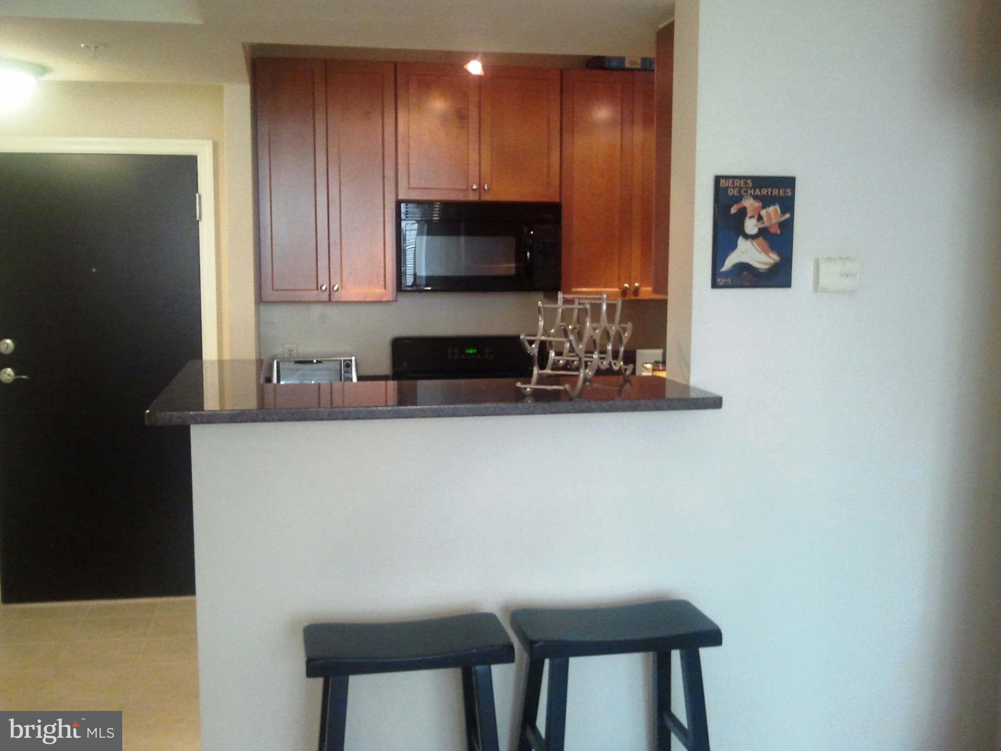 851 North Glebe Road, Unit 1018 Arlington, VA 22203 - Photo 4 of 24 a kitchen with stainless steel appliances a microwave a sink and cabinets