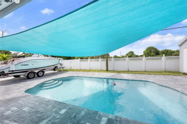 a view of a backyard with swimming pool and furniture