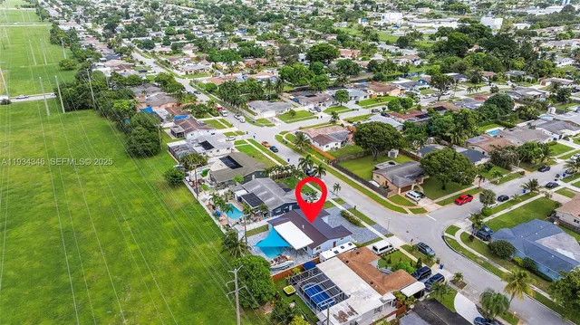 an aerial view of residential houses with outdoor space and trees