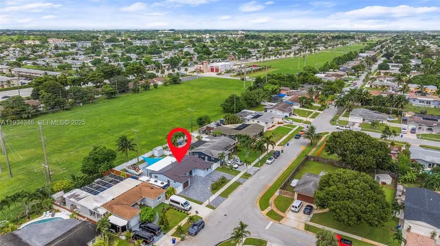 an aerial view of residential houses with outdoor space and parking