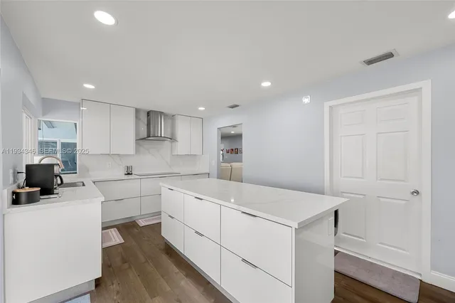 a kitchen with white cabinets appliances and sink