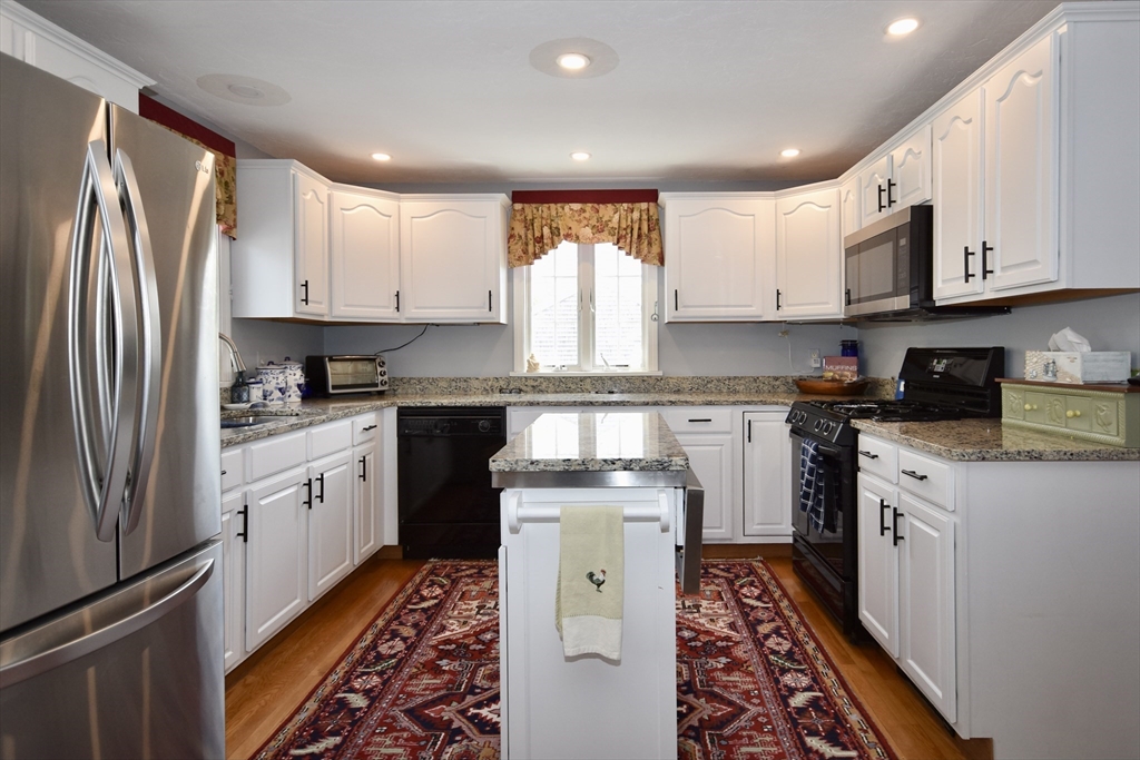 6 Oakbluff Road Bourne, MA 02562 - Photo 17 of 36 a kitchen with stainless steel appliances granite countertop a refrigerator sink and cabinets