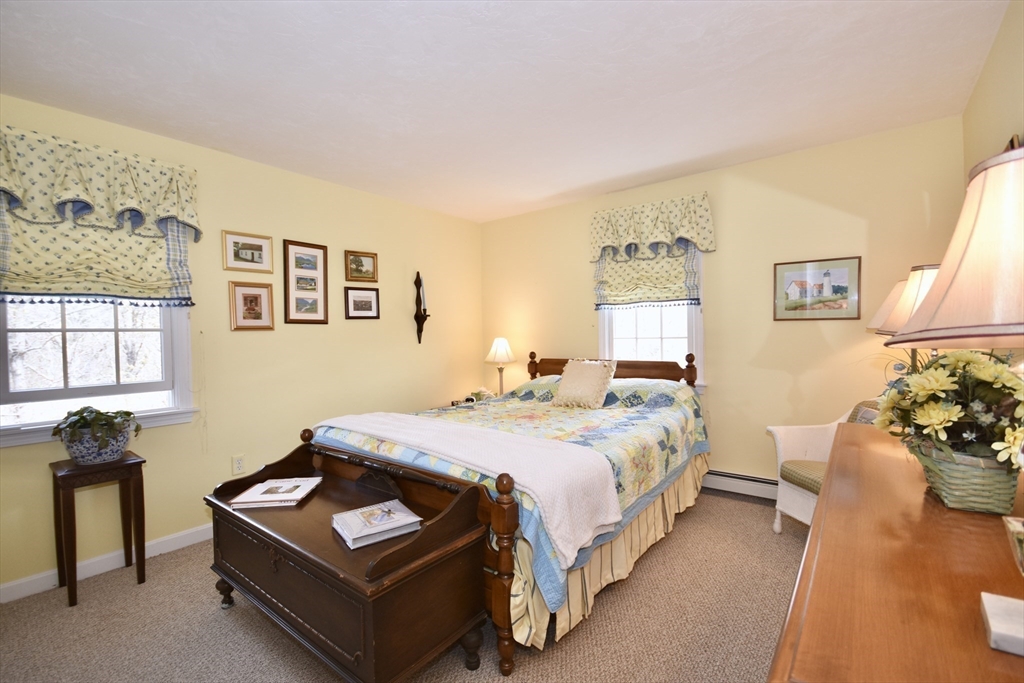 6 Oakbluff Road Bourne, MA 02562 - Photo 30 of 36 a bedroom with a bed and a chandelier