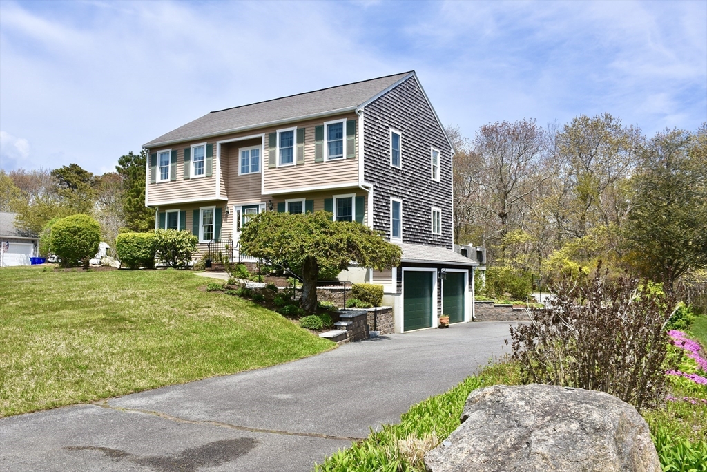 6 Oakbluff Road Bourne, MA 02562 - Photo 9 of 36 a front view of a house with garden and trees