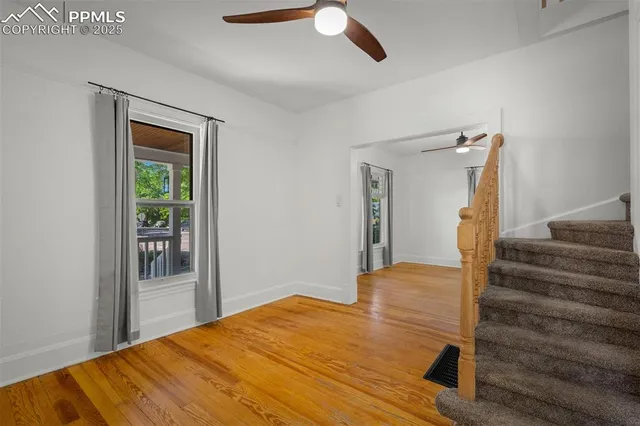 a view of a livingroom with wooden floor and stairs