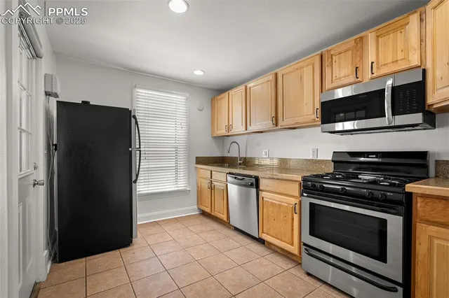 a kitchen with stainless steel appliances granite countertop a refrigerator stove and microwave