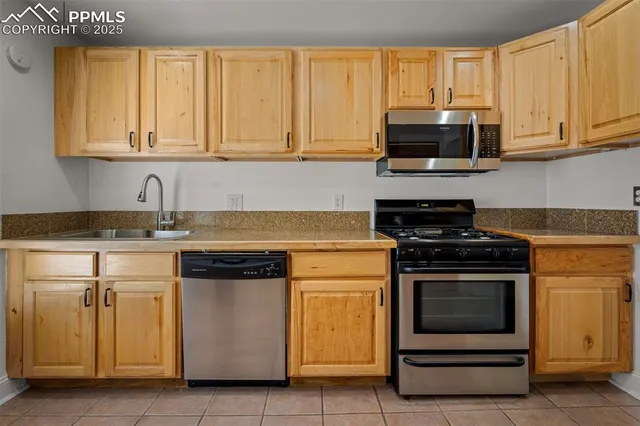 a kitchen with stainless steel appliances granite countertop white cabinets and a stove top oven