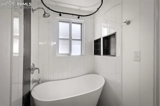 a white bath tub sitting next to a bathroom