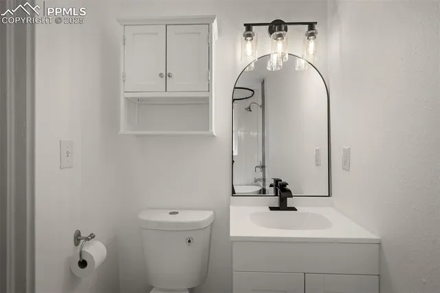 a bathroom with a sink and mirror with toilet