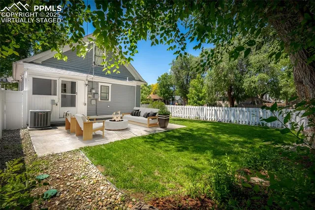 a view of a house with a yard and large tree