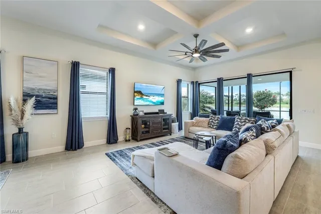 a living room with furniture a flat screen tv and a large window