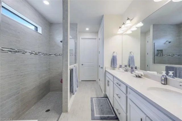 a spacious bathroom with a double vanity sink mirror and shower