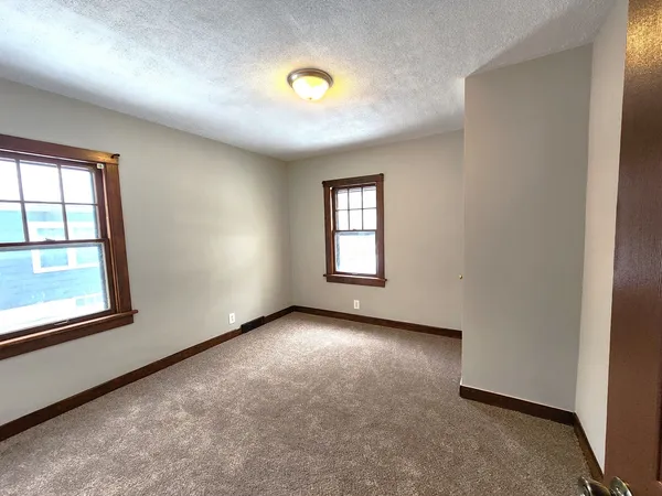 an empty room with windows and closet