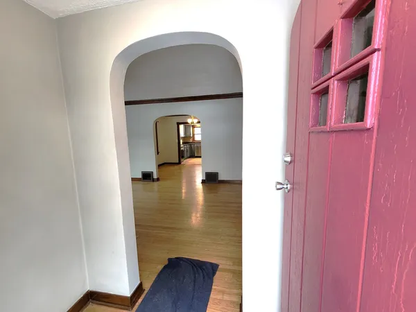 a hallway with a wooden floor and a dining room