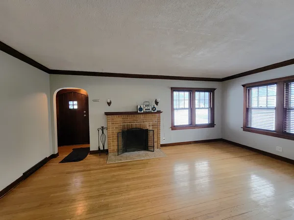 a view of an empty room with window and fire place