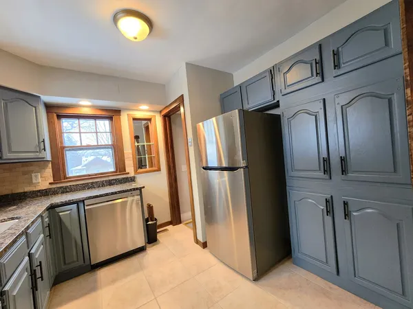a kitchen with stainless steel appliances granite countertop a refrigerator and a stove