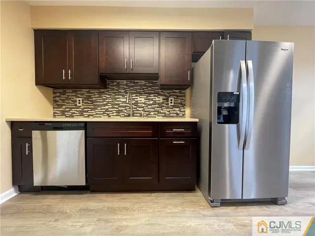 a kitchen with stainless steel appliances granite countertop a refrigerator and a stove