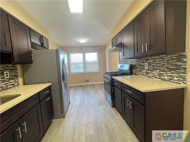 a kitchen with stainless steel appliances granite countertop a sink stove and refrigerator