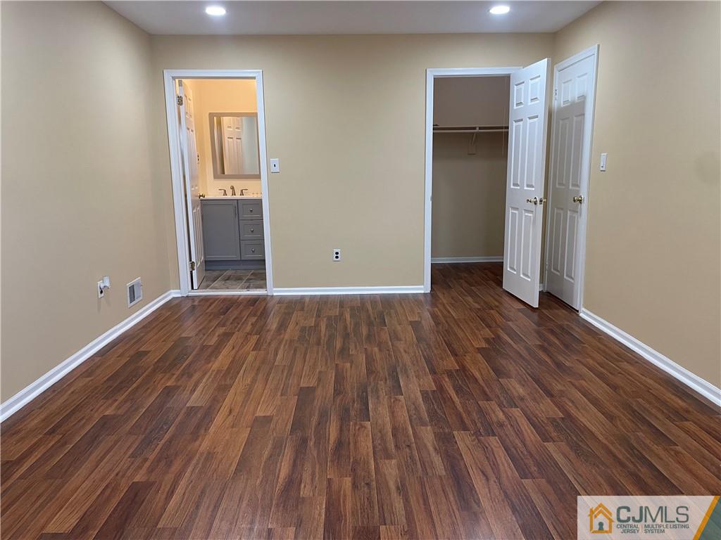 93 C Woodbridge Terrace, Unit 9303 Woodbridge, NJ 07095 - Photo 7 of 14 a view of an empty room with wooden floor and a window