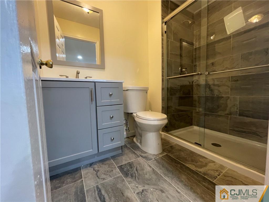 93 C Woodbridge Terrace, Unit 9303 Woodbridge, NJ 07095 - Photo 10 of 14 a bathroom with a sink a toilet and shower